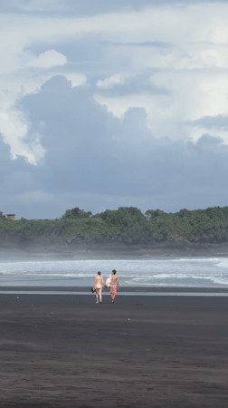 Beachgoers enjoy early morning on Kediri's black sand shore