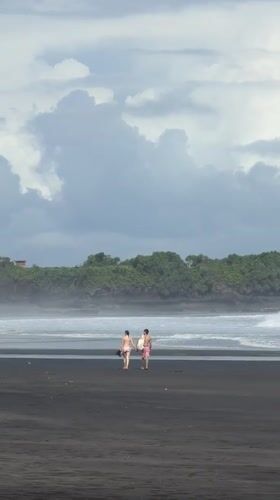 Beachgoers enjoy early morning on Kediri's black sand shore