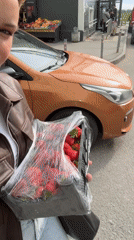 Person carries crate of strawberries in Saint Petersburg