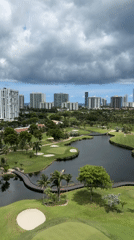 Drone footage over Aventura golf course with city skyline backdrop
