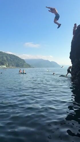 Cliff jumping into calm blue water at Sarpi's beach