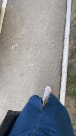 Person walks sidewalk in Saratov wearing casual clothing