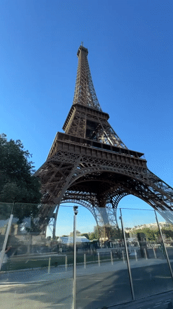 Eiffel Tower from below, reflected in a glass barrier