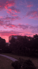 Pink and purple sunset sky over a silhouetted modern building