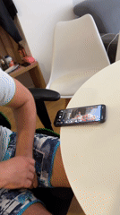 Man watches smartphone videos at outdoor table in Montenegro