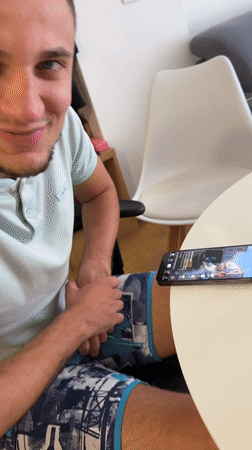 Man watches smartphone videos at outdoor table in Montenegro