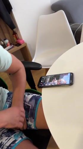 Man watches smartphone videos at outdoor table in Montenegro