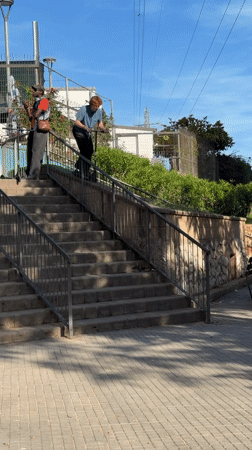 Young man rides scooter down stairs in Spanish town