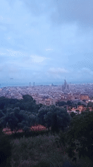 Barcelona cityscape filmed showing Sagrada Familia construction under overcast skies