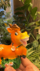 Person displays decorated orange horse figurine in Kursk