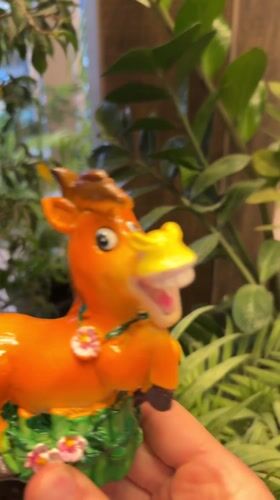 Person displays decorated orange horse figurine in Kursk