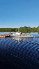Crane boat pulls barge through Russian waters near Gorka