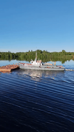 Crane boat pulls barge through Russian waters near Gorka