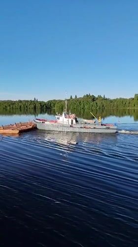 Crane boat pulls barge through Russian waters near Gorka