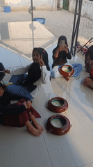 Kids practice hand drumming outdoors in Swarga Bara, Indonesia