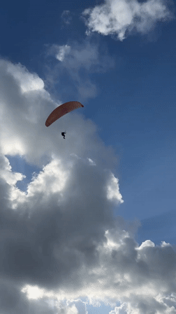 Paraglider spotted soaring over Bat Yam in clear afternoon skies