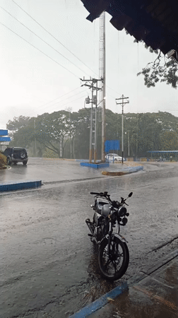 Heavy rain creates puddles around parked motorcycle in Monagas
