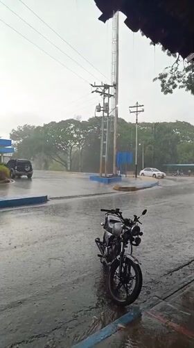 Heavy rain creates puddles around parked motorcycle in Monagas
