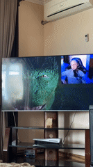Television displays split-screen content including Spider-Man movie scenes