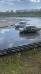 Tandem drifting on wet asphalt in Tolyatti, vintage Soviet iron