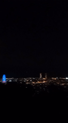 Shaky nighttime video captures Barcelona cityscape with illuminated tower