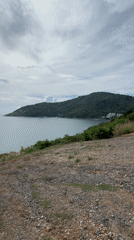 Calm waters viewed from rocky hillside in Rawai, Thailand