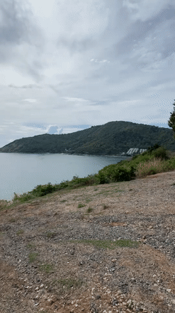 Calm waters viewed from rocky hillside in Rawai, Thailand