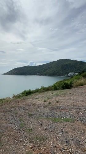 Calm waters viewed from rocky hillside in Rawai, Thailand