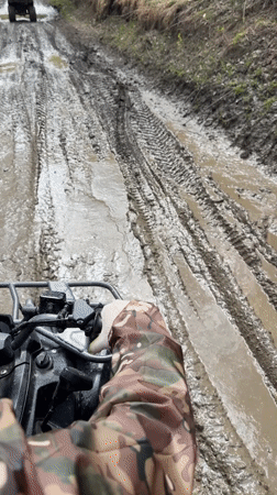 ATV riders traverse muddy forest roads near Manskii, Russia