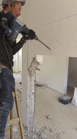 Worker demolishes wall with jackhammer in Bat Yam