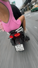 Pillion ride through Bangkok streets, pink outfit in frame