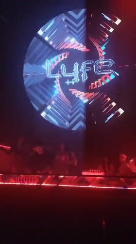 Nightclub LED screen shows 'Lyfe' branding with kaleidoscopic visuals