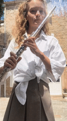 Woman plays flute, swims in Budva Montenegro morning