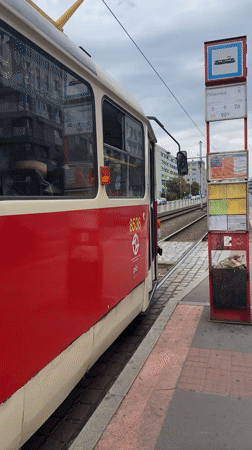 Red and cream tram paused at a Prague stop