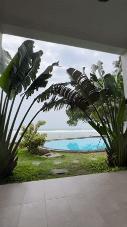 Guitarist plays indoors as waves crash outside Sri Lankan coast