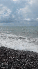 Cloudy day at Batumi's pebble beach, people by the water