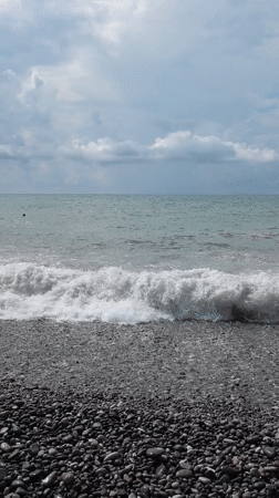 Cloudy day at Batumi's pebble beach, people by the water