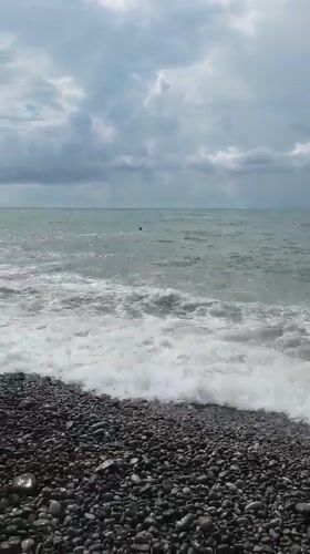 Cloudy day at Batumi's pebble beach, people by the water