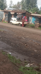 Toyota truck transports passengers on muddy rural road