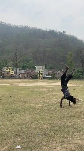 Person performs backflips, poses by river in Chisapani Nepal
