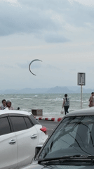 Kite surfing and parked trucks on a cloudy Ko Samui coast