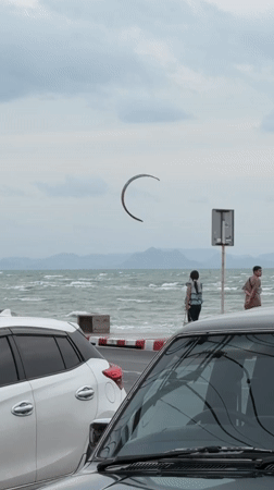 Kite surfing and parked trucks on a cloudy Ko Samui coast