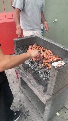 Rooftop shrimp barbecue gathering documented in Turin