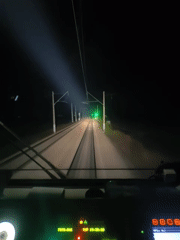 Train operator records nighttime cab view of illuminated tracks