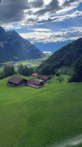 Cable car riders document scenic Swiss alpine valley views