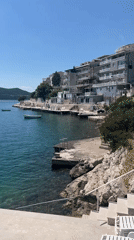 Sunny coastal bay scene with boats and relaxation furniture documented