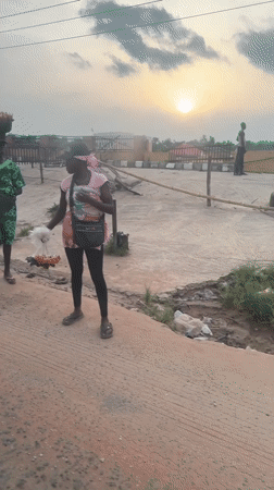 Two people spotted on deteriorating road in Ikire at sunset