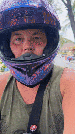 Motorcyclist rides past busy Karon Beach in Thailand