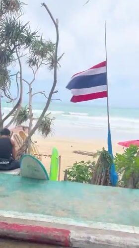 Motorcyclist rides past busy Karon Beach in Thailand