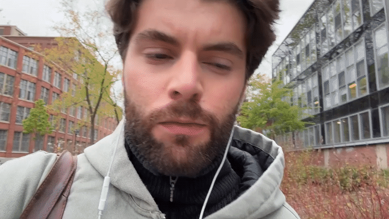 Man walks Montreal campus taking selfies on overcast evening